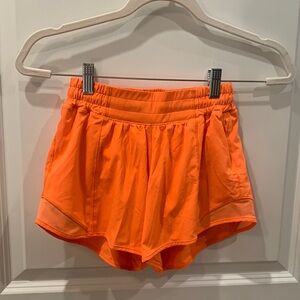 Orange Lululemon women’s athletic shorts. 4” inseam. Size 2 Tall.